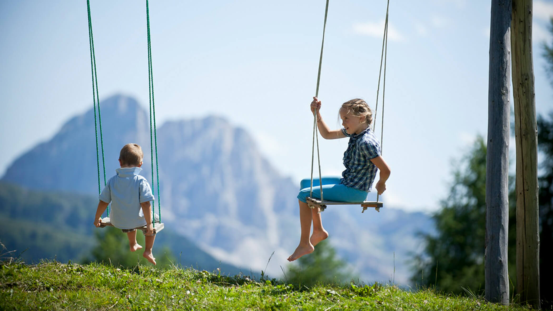 Zwei Kinder beim Schaukeln im Sommer